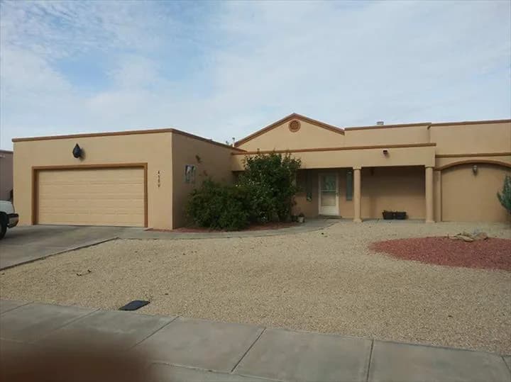 Single-storey tan stucco home with a two-car garage after an exterior repaint